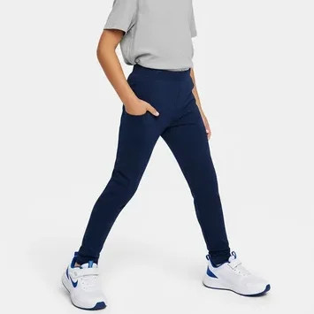 Smiling young boy wearing navy blue pocket leggings with a grey t-shirt and sneakers, representing RYZEAL as a kid's pocket leggings manufacturer in Bangladesh.