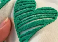 Tooth embroidery technique with ridged, textured stitching patterns.