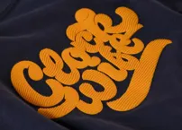 Patch embroidery technique for bold, removable branding elements.