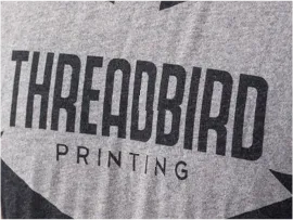 Discharge printing used to remove dye and create soft-feel graphics.
