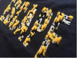 Flock print technique creating a velvety raised texture on apparel.
