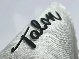 Rubber print technique adding flexible raised ink on garments.