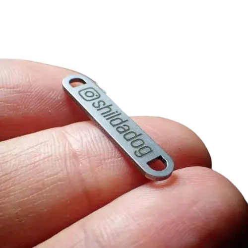 Custom metal badge used for high-end branding on apparel and accessories.